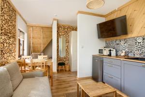uma cozinha e sala de estar com um sofá e uma mesa em Apartamenty Kucovka 11 em Brzegi