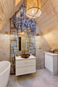 a bathroom with a sink and a mirror and a tub at Apartamenty Kucovka 11 in Brzegi