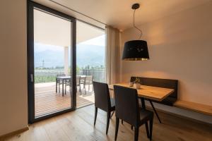 a dining room with a table and chairs and a large window at Feldhof Vilpian- Urlaub auf dem Bauernhof in Vilpiano