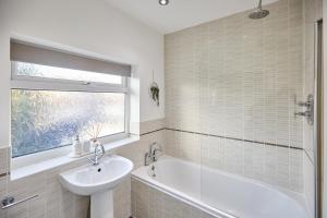 a bathroom with a white tub and a sink and a window at Host & Stay - Newsam Crescent in Eaglescliffe
