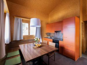 una cocina con una mesa con un bol de fruta. en Holiday Home Komfort Aclas Maiensäss Resort-1 by Interhome, en Urmein