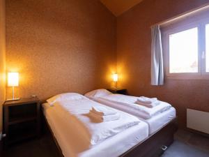 UrmeinにあるHoliday Home Komfort Aclas Maiensäss Resort-1 by Interhomeのベッドルーム1室(大型ベッド1台、タオル付)