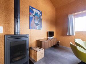 a living room with a fireplace and a television at Holiday Home Komfort Aclas Maiensäss Resort-1 by Interhome in Urmein