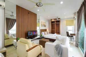 Una sala de estar con una cama, un sofá y un televisor. en Comfy Studio/Gurney/Mansion One, en George Town