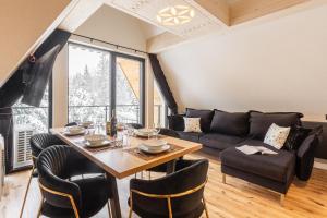 Tatry Residence SPA في كوشتيليسكا: غرفة معيشة مع طاولة وأريكة