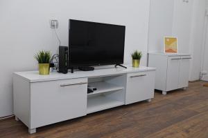 a white entertainment center with a flat screen tv on it at Central Studio Apartman in Šabac