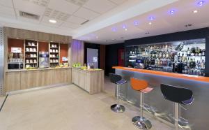 a bar in a hotel with chairs and a bar counter at ibis Styles Flers in Flers