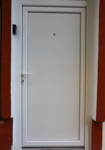 een witte deur aan de zijkant van een gebouw bij Central Studio Apartman in Šabac