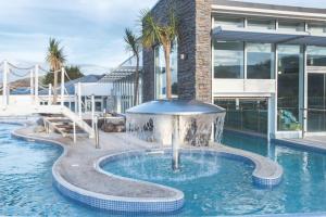 a pool with a fountain in front of a building at Paddock 39 Caravan - Weymouth Bay in Preston