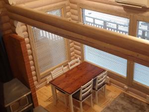 un tavolo in legno in una stanza con due finestre di Holiday Home Lokki by Interhome a Karuna Altre 16 foto