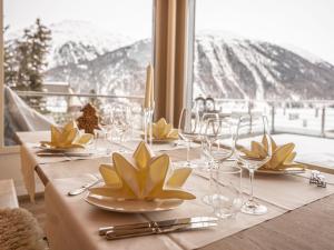 a table with plates and glasses and a view of the mountain at Apartment Chesa Crusch 7 by Interhome in Samedan +25 photos