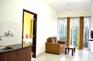 a bathroom with a sink and a chair and a mirror at Grand Suites Yelahanka in Bangalore