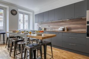 kuchnia ze stołem i stołkami barowymi w obiekcie Superb Large and New 4bds Flat - Heart of Paris 10 w Paryżu