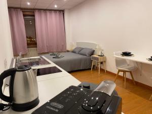 a room with a kitchen and a bed in a room at Les trois merveilles in Cesena