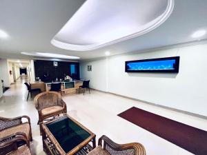 a waiting room with chairs and a tv on the wall at MADAPARAMBIL RESIDENCY in Alwaye