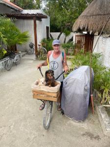 un hombre montando una bicicleta con un perro en una caja en Casa Molly en Holbox Island