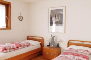 a bedroom with two beds and a picture on the wall at CASA PARADISO - Vista valle in Cavalese