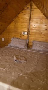 duże łóżko w drewnianym pokoju z drewnianym sufitem w obiekcie شالية ديما الريفي ٢ w mieście As Sayl aş Şaghīr