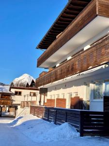 uma casa com uma varanda com neve no chão em Seefeld-apartman em Seefeld in Tirol
