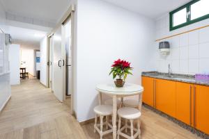 una cucina con tavolo, due sgabelli e lavandino di La Esperanza downtown 3 bd apt a El Rosario