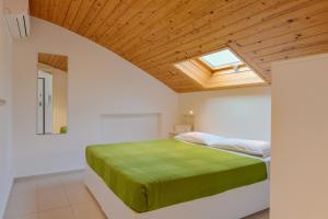 een slaapkamer met een bed met een houten plafond bij Appartamenti Sud Est in Marina di Ragusa