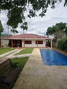 Casa de descanso acacias meta في اكاثياس: منزل به مسبح بجانب مقعد