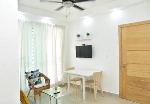 a living room with a table and a ceiling fan at ocupado favor no reservar in Santo Domingo