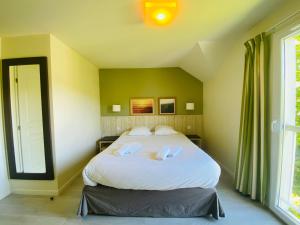 1 dormitorio con 1 cama blanca grande en una habitación en Le Cottage de Matys, en Branville