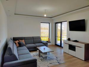 uma sala de estar com um sofá e uma televisão em Villa Alex em Veľká Lomnica
