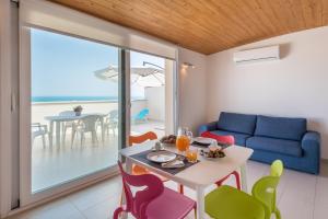 ein Wohnzimmer mit einem Tisch, Stühlen und einem Sofa in der Unterkunft Appartamenti Sud Est in Marina di Ragusa