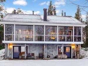 a house with large windows and a roof at Holiday Home Äkäsjärven lomamökit 2 by Interhome in Muonio