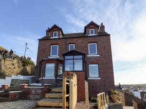 a red brick building with a staircase in front of it at Mariner's Watch in Whitby