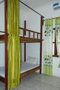 a bedroom with two bunk beds with green curtains at Green's Nungwi in Nungwi