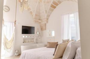 a white bedroom with a bed and a tub at Apulia Charming Suites - Casa Rossa Suite Perla e Suite Corallo in Savelletri di Fasano