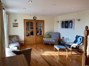 uma sala de estar com um sofá, cadeiras e uma mesa em Stunning hideaway on the Wild Atlantic Way em Knocknaud