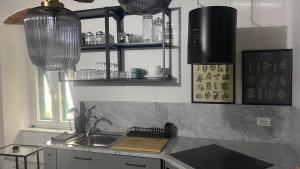 uma cozinha com um lavatório e algumas luzes de vidro em Stupendo bilocale nuovissimo con finiture di lusso em Carrara