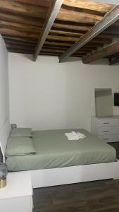 uma cama num quarto branco com tectos em madeira em Stupendo bilocale nuovissimo con finiture di lusso em Carrara