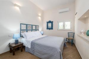 una camera con letto e tavolo con sedia di Villa Philos a Ostuni
