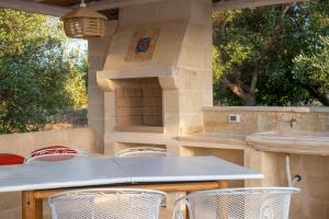 un patio con tavolo, sedie e griglia di Villa Philos a Ostuni