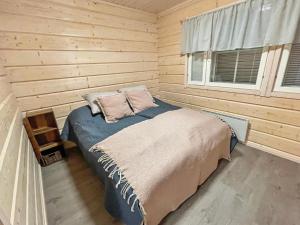 a bedroom with a bed in a wooden cabin at Holiday Home South point apartments 4a by Interhome in Sirkka