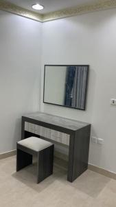 una mesa con un banco y un espejo en la pared en Reef 18 by Al Azmy en Riad
