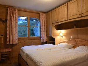 ein Schlafzimmer mit einem großen Bett und einem Fenster in der Unterkunft Apartment Ardève 1 by Interhome in Ovronnaz