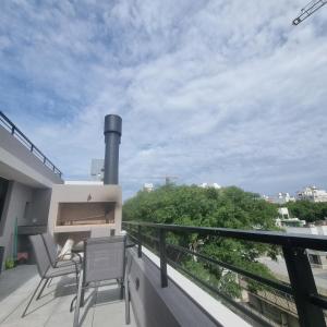 Un balcón con 2 sillas y vistas. en Exclusivo Penthouse en Cordon Soho con Parking y STARPLUS incluidos, en Montevideo
