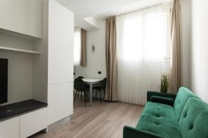 ein Wohnzimmer mit einem grünen Sofa und einem Tisch in der Unterkunft YouHosty - Montebianco 4/6 in Mailand