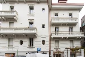 ein weißes Gebäude mit Balkon auf der Seite in der Unterkunft YouHosty - Montebianco 4/6 in Mailand