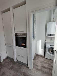a kitchen with white cabinets and a washer and dryer at [WHITE & WOOD house in Rome] in Rome