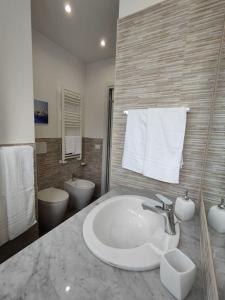 a bathroom with a sink and a toilet and towels at [WHITE & WOOD house in Rome] in Rome