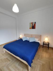 a bedroom with a blue bed and a wooden floor at [WHITE & WOOD house in Rome] in Rome