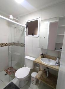 La salle de bains est pourvue de toilettes, d'un lavabo et d'une douche. dans l'établissement Excelente Apartamento no Centro de Bertioga, à Bertioga