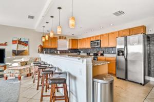 a kitchen with a bar and bar stools at Palms of Treasure Island 405 in St Pete Beach